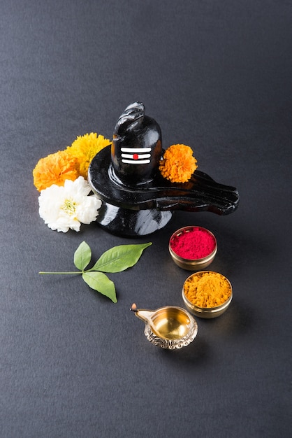 Photo shiva linga décoré de fleurs et bel patra ou feuille et haldi kumkum pour pooja ou adoration de lord shiva ou shankar bhagwan