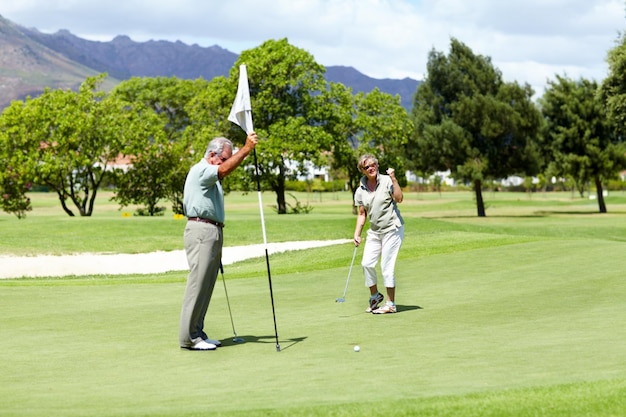 Sho si proche Une dame senior levant son poing de déception alors qu'elle manque de peu le trou lors d'une partie de golf