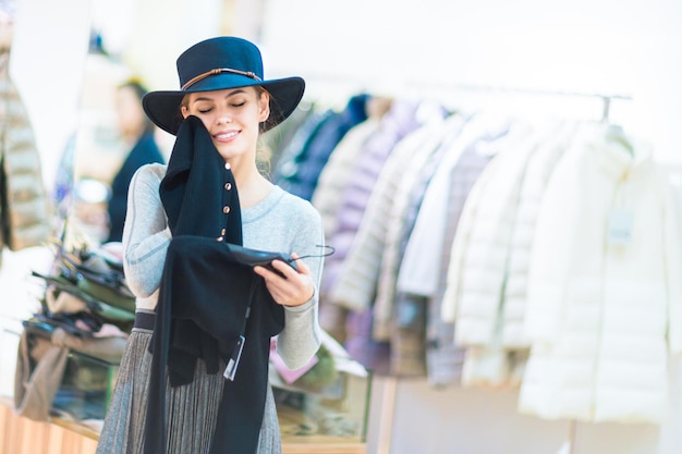 Shopping Belle fille heureuse dans une boutique Essayer une robe et un chapeau