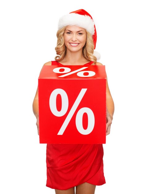 shopping, cadeaux, noël, concept de noël - femme souriante en bonnet de noel avec signe de vente de pourcentage rouge