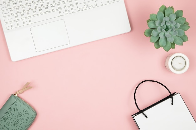 Shopping Concept En Ligne. Mains De Femmes Avec Téléphone Et Ordinateur Portable Sur Une Surface Rose. Vue De Dessus, Espace Copie.