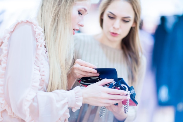 Shopping Filles gaies dans une boutique regardant une pochette Ambiance ludique