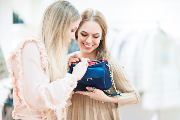 Shopping Filles gaies dans une boutique regardant une pochette Ambiance ludique