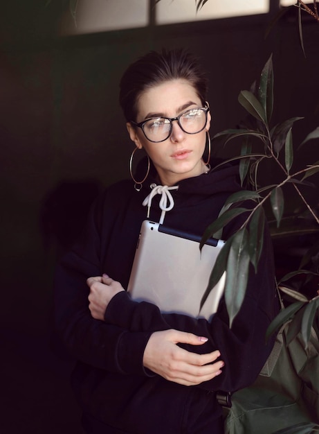 Shortcut hipster girl wearing glasses regardant la fenêtre à l'intérieur du café vert