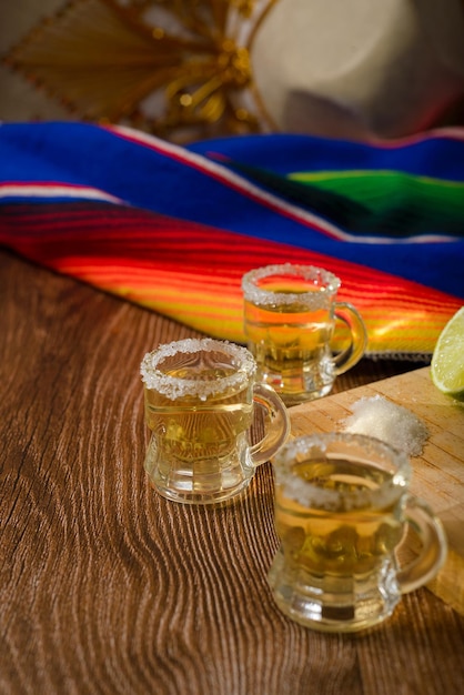 Shots de tequila avec sel et citron vert sur une table de bar Shots de tequila et d'éléments typiquement mexicains