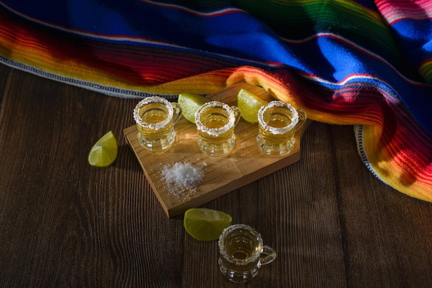 Shots de tequila avec sel et citron vert sur une table de bar Shots de tequila et d'éléments typiquement mexicains