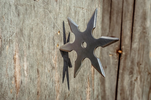 Shuriken jetant une étoile ninja japonaise traditionnelle arme froide coincée dans un fond en bois