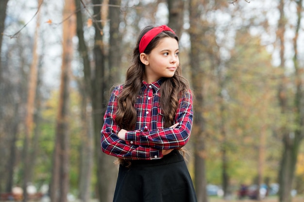 Si bel enfant profite du temps d'automne fille rétro a son propre style petite beauté à la recherche d'une fille à la mode en uniforme scolaire enfant marche dans le parc d'automne l'automne est l'heure de marcher mode scolaire pour les enfants