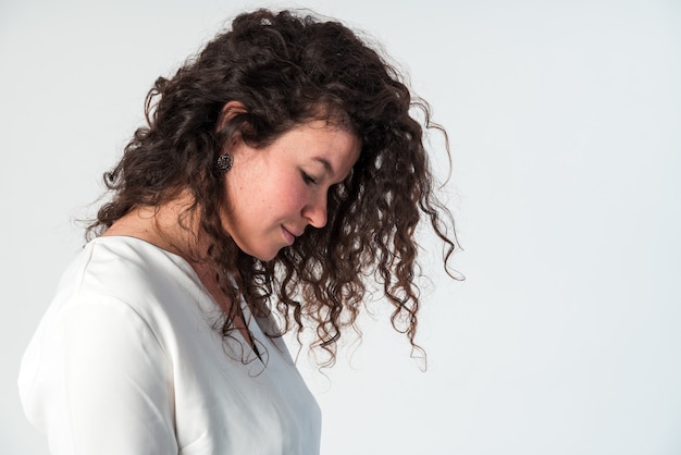 Si tendre. Vue latérale du profil portrait de calme grave belle brune femme caucasienne en blouse blanche décontractée avec maquillage nude debout et regardant vers le bas