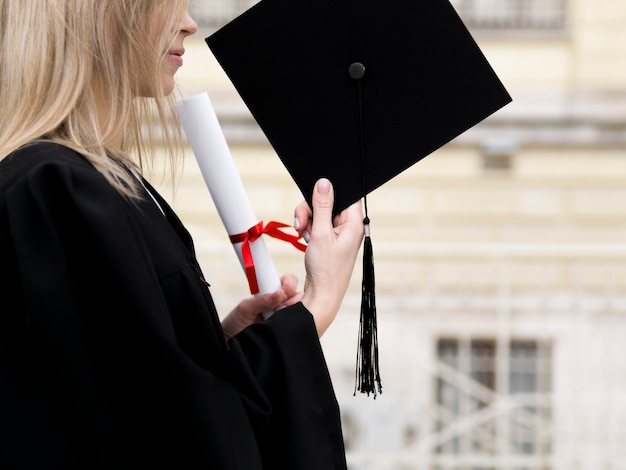Photo sideways jeune femme célébrant son diplôme