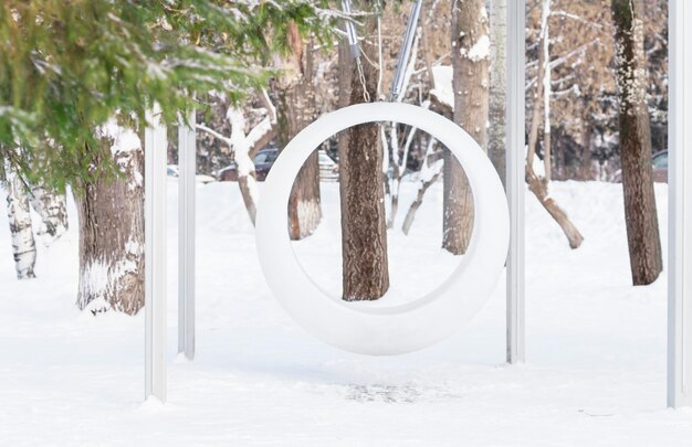 Siège de balançoire en plastique blanc rond vide dans le parc d'hiver mise au point sélective copie espace paysage naturel