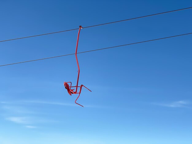 Un siège rouge de l'ascenseur de ski dans les montagnes sur un fond de ciel bleu