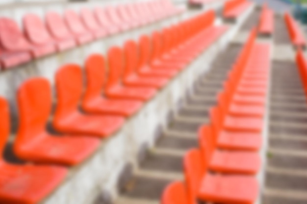 Photo des sièges en plastique rouge floues et vides du stade