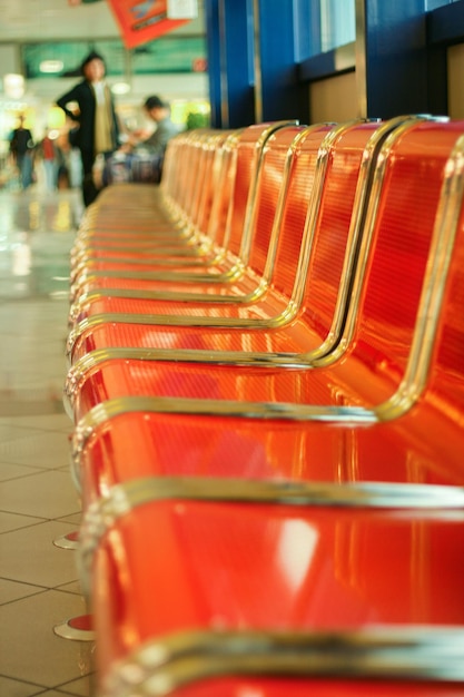 Sièges vides en métal rouge dans le hall de l'aéroport