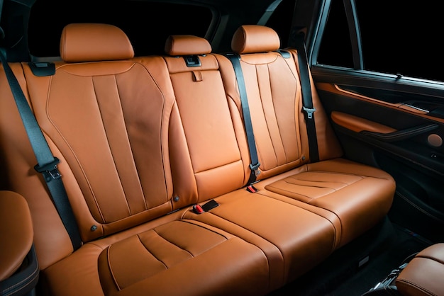 Des sièges de voiture en cuir rouge, des sièges arrière pour passagers, un cockpit moderne et confortable.