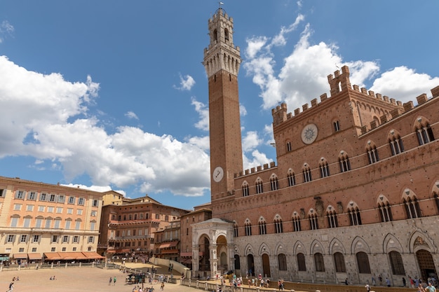 Sienne, Italie - 28 juin 2018 : Vue panoramique du Palazzo Pubblico (mairie) est un palais et Torre del Mangia est une tour en ville sur la Piazza del Campo. Journée ensoleillée d'été et ciel bleu dramatique