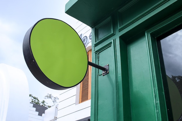 Signage de magasin arrondi en blanc pour maquette Panneau d'affichage arrondi suspendu sur le mur vert