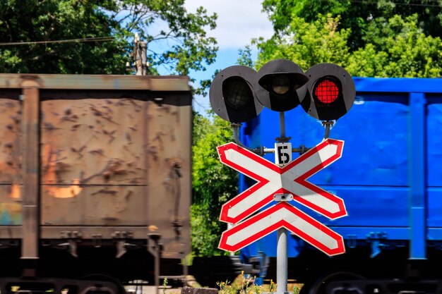 Signal rouge de sémaphore et panneau d'arrêt devant le passage à niveau avec passage de train