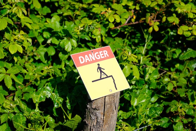 Photo signe d'avertissement rouge jaune texte de danger indiquant le risque de chute lors de l'approche de la falaise raide