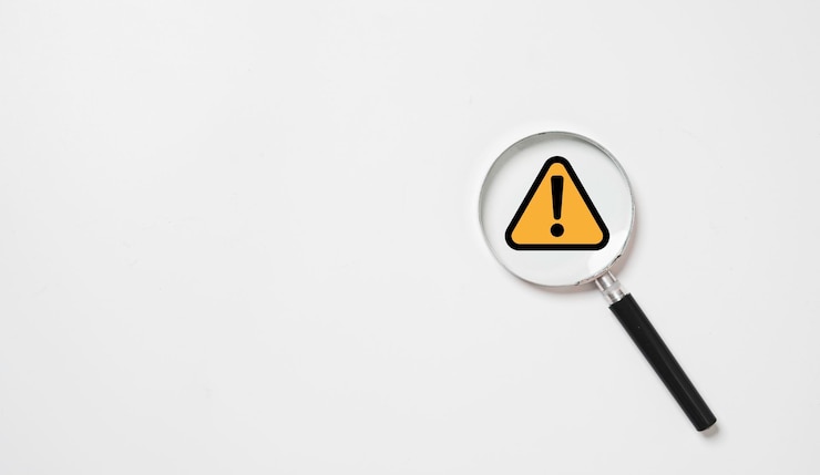 Photo signe d'avertissement en triangle noir et jaune à l'intérieur de la loupe pour la notification d'erreur et le concept de maintenance