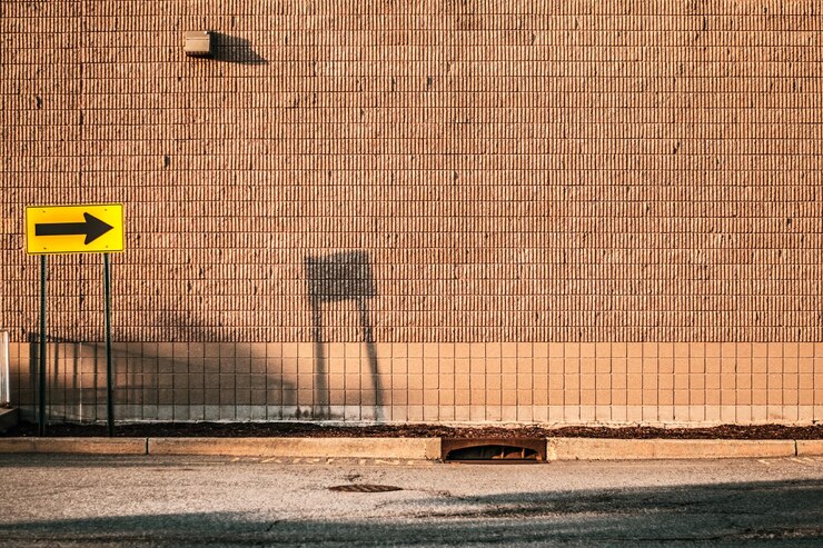 Photo signe directionnel sur le trottoir contre le mur