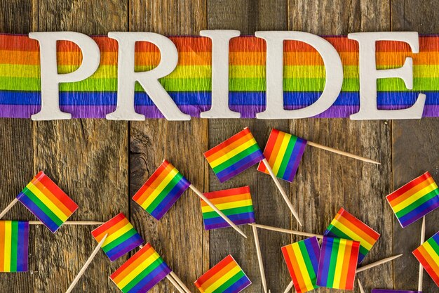 Signe de fierté gay blanc sur fond de bois.