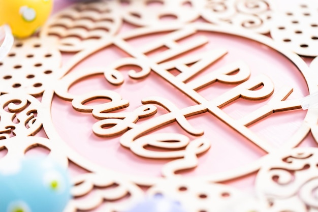 Signe de Joyeuses Pâques et oeufs de Pâques peints sur fond rose.