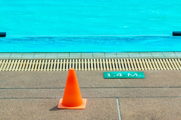 Photo le signe orange du cône et de la profondeur au bord de la piscine d'une piscine locale