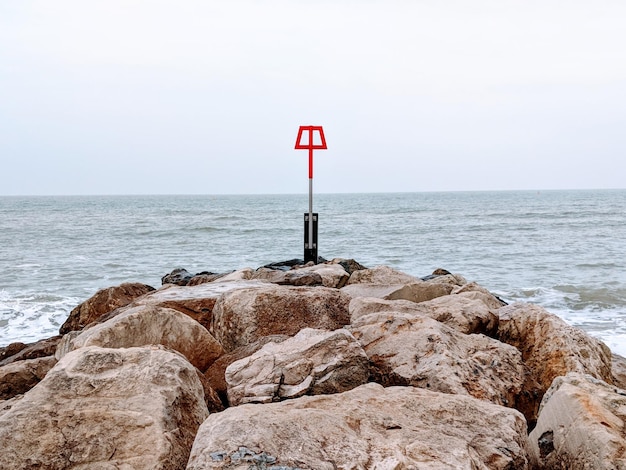 Photo signe sur le rocher par la mer contre le ciel