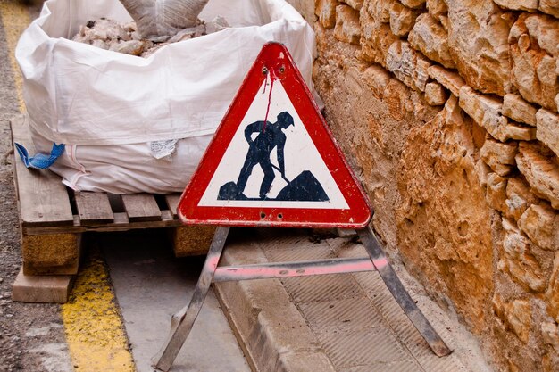 Photo signe routier pendant la construction par un mur de pierre