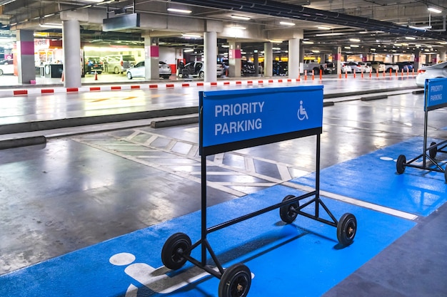 Photo signe de stationnement prioritaire label bleu pour un parking dans un centre commercial.