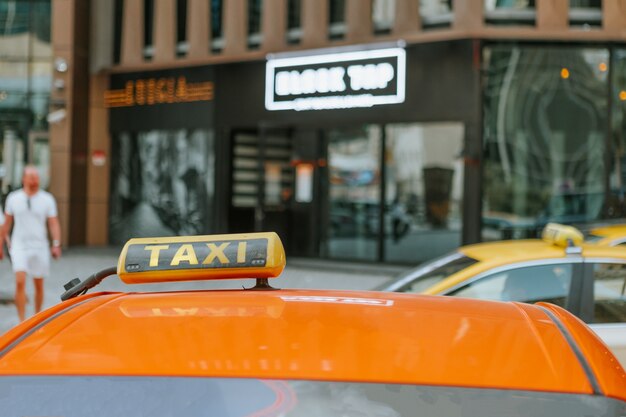 Signe de taxi sur le toit d'une voiture dans une rue