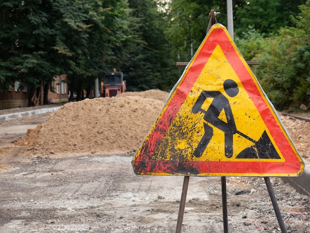 Photo signe de travaux routiers sur le fond d'une route en construction