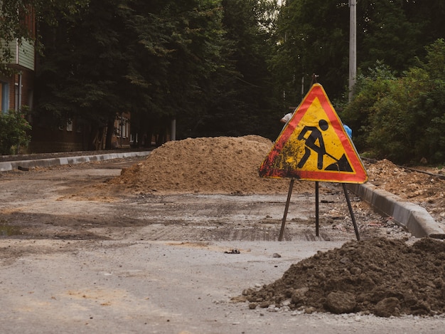 Signe de travaux routiers sur le fond d'une route en construction