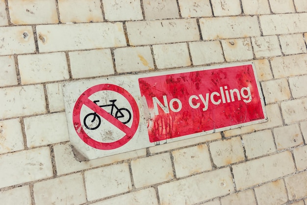 Signer Pas de vélo sur un mur de brique sale
