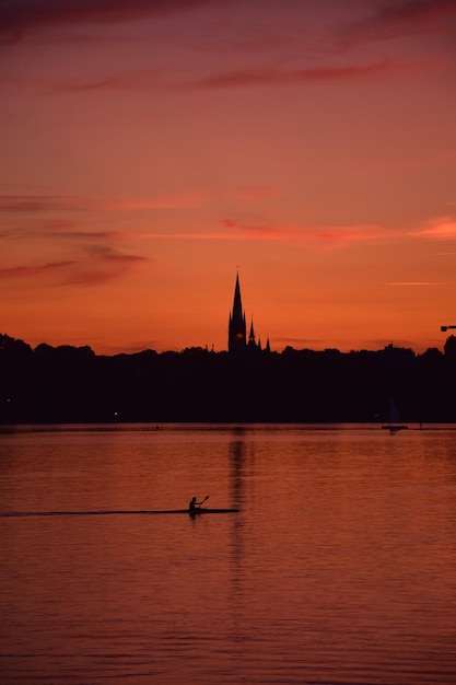 Photo silhouette d'un bateau dans le lac au coucher du soleil