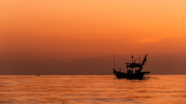 Silhouette de bateau de pêche avec coucher de soleil en Thaïlande.