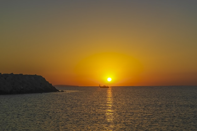 Silhouette de bateau de pêche sur la mer au beau lever de soleil