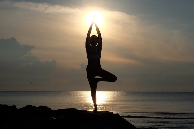 Silhouette de la beauté de la posture d&#39;yoga avec fond de vue mer