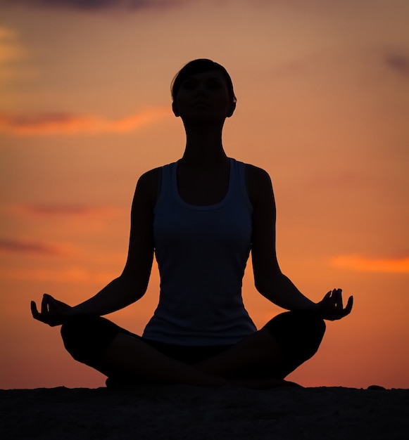 Silhouette d'une belle femme de yoga le matin