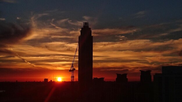 Photo silhouette construite contre le ciel orange