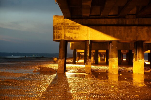 Photo silhouette construite sur la plage contre le ciel