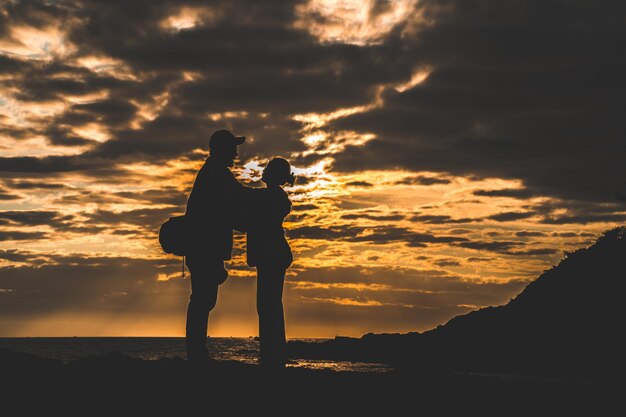 Silhouette d'un couple d'amoureux au lever du soleil