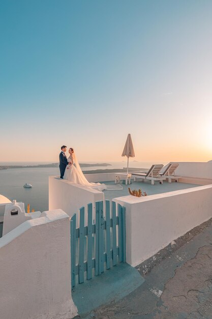 Silhouette d'un couple d'amoureux sur fond coucher de soleil, ciel pastel, mer des îles. Santorin