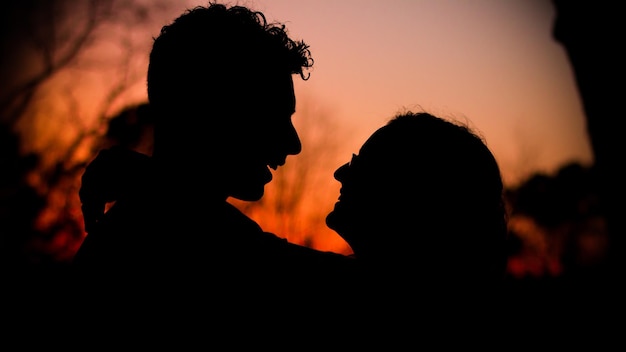 Photo silhouette d'un couple au coucher du soleil