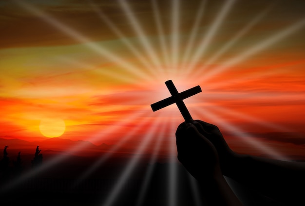 Silhouette de la croix dans la main humaine, l'arrière-plan est le lever du soleil, Le pour la religion chrétienne, le concept divin, céleste, céleste ou divin
