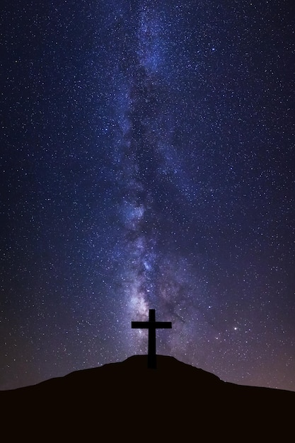 Silhouette de la croix et de la voie lactée Ciel nocturne avec des étoiles et de la poussière spatiale dans l'univers