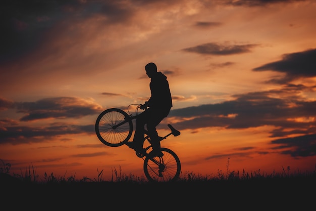 silhouette d'un cycliste au coucher du soleil