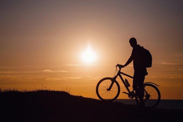 Silhouette de cycliste en mouvement au beau coucher de soleil