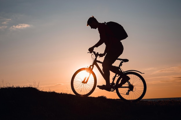 Silhouette de cycliste en mouvement au beau coucher de soleil